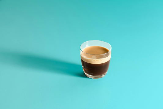 Taza de café de especialidad con crema dorada en la mesa, listo para degustar en casa.